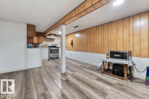 Open-concept living area with wood-finish flooring, wood paneling, and a recessed lighting fixture - 712 Lee Ridge Road, Edmonton, AB 
