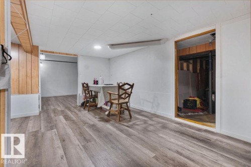 Spacious interior featuring wood-finish flooring, white paneled walls, and a recessed ceiling light - 712 Lee Ridge Road, Edmonton, AB 