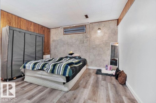 Room featuring wood-finish flooring, two distinct wall finishes, and a single window - 712 Lee Ridge Road, Edmonton, AB 