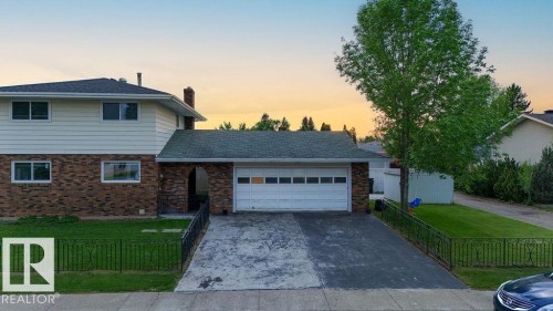 Two-story residence featuring a brick and siding facade, an attached garage, and a paved driveway - 712 Lee Ridge Road, Edmonton, AB 