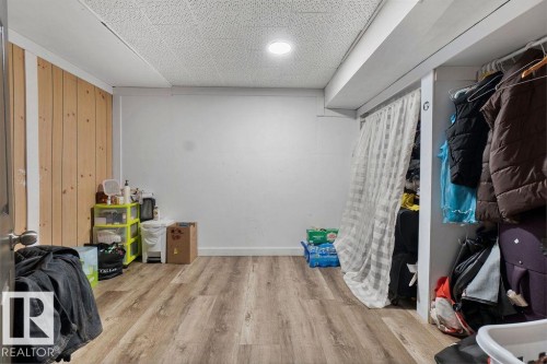 Room featuring wood-finish flooring, recessed lighting, and a partially wood-paneled accent wall - 712 Lee Ridge Road, Edmonton, AB 
