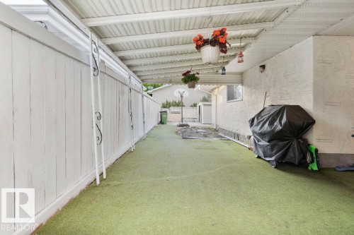 Covered patio area featuring a corrugated metal roof and textured stucco wall - 712 Lee Ridge Road, Edmonton, AB 