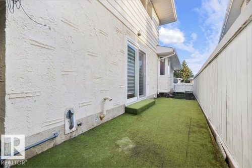 Sliding glass door opening to an outdoor area featuring artificial turf and a privacy fence - 712 Lee Ridge Road, Edmonton, AB 