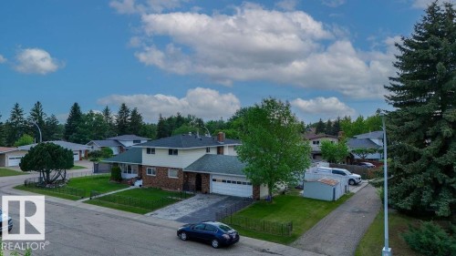 Split-level residence featuring a two-car garage, brick and siding exterior, and a green shingle roof - 712 Lee Ridge Road, Edmonton, AB 