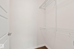 Closet featuring white wire shelving, a white paneled door with polished chrome hardware, and brown carpet flooring - 