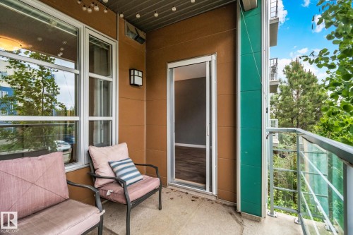 Private balcony featuring a concrete floor, glass railing, and modern exterior lighting - 217 2588 Anderson Way, Edmonton, AB 