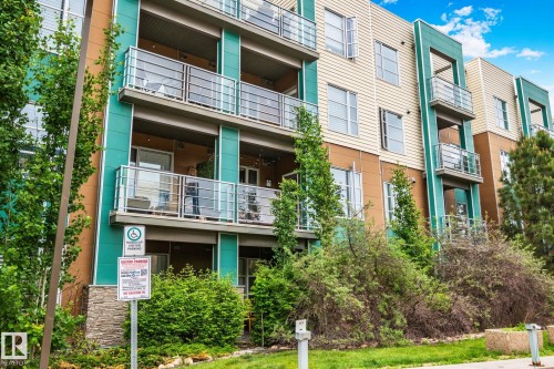 Contemporary multi-story building featuring balconies with glass and metal railings - 217 2588 Anderson Way, Edmonton, AB 