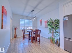 Dining area featuring wood-finish flooring and a rectangular window with horizontal blinds - 