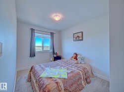 Carpeted room with a double-paned window featuring blinds and dark curtains, white baseboards, and a flush mount ceiling light fixture - 