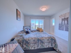 Carpeted bedroom featuring a large window, neutral wall paint, and a flush mount ceiling light fixture - 