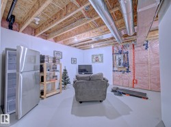 Unfinished basement space featuring exposed wood joists and ductwork, with a combination of finished and insulated walls - 