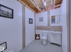 Compact bathroom featuring a white toilet, freestanding vanity with integrated sink, and a framed mirror - 
