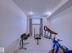 Finished lower level space featuring a window with wooden trim and a drop ceiling - 