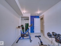 Recessed lighting illuminates a versatile interior space featuring light-colored flooring and white walls - 