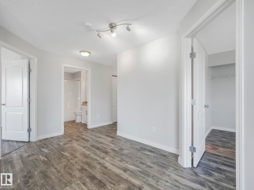 Interior space featuring wood-finish flooring, light grey painted walls, and white trim - 2406 320 Clareview Station Drive, Edmonton, AB 