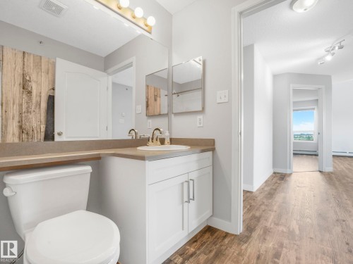 Bathroom featuring a single vanity with white cabinetry, a built-in sink, and a large mirror - 2406 320 Clareview Station Drive, Edmonton, AB 