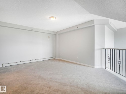 Carpeted interior space with a dropped ceiling and recessed lighting - 2406 320 Clareview Station Drive, Edmonton, AB 