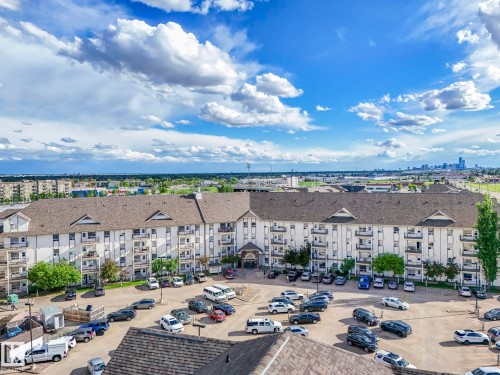 Multi-story residential building featuring white exterior siding and dark shingle roofing - 2406 320 Clareview Station Drive, Edmonton, AB 