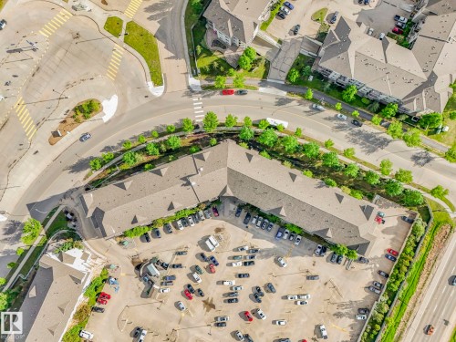 Aerial view of a commercial property featuring multiple rooflines, extensive paved parking, and direct road access - 2406 320 Clareview Station Drive, Edmonton, AB 
