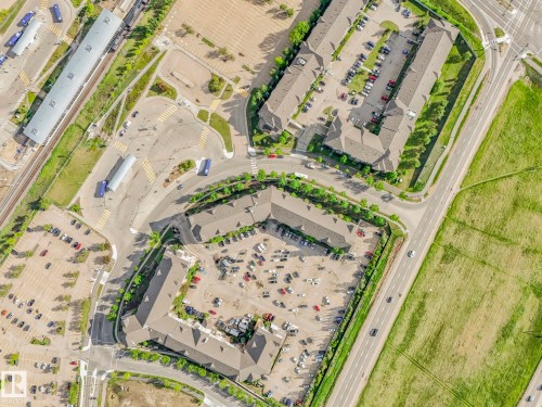 Aerial perspective showcasing a mixed-use development with multi-story buildings and substantial surface parking - 2406 320 Clareview Station Drive, Edmonton, AB 
