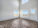 Soaring vaulted ceilings complement wood-finish flooring in this bright interior space - 2406 320 Clareview Station Drive, Edmonton, AB 