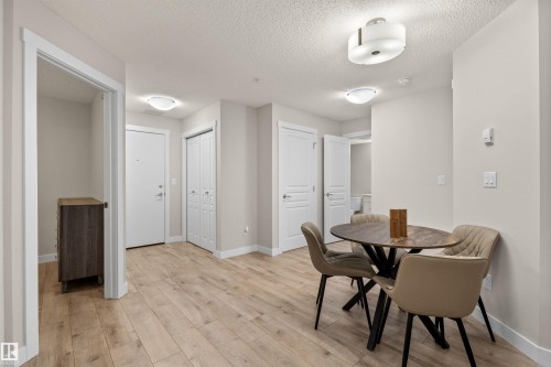 Light wood-finish flooring throughout, complemented by neutral wall tones and white trim - 210 2229 44 Avenue, Edmonton, AB 