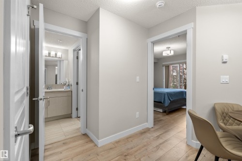 Hallway with wood-finish flooring and light neutral wall paint - 210 2229 44 Avenue, Edmonton, AB 