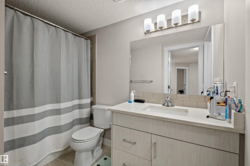 Bathroom featuring a light wood-finish vanity with a white countertop and integrated sink - 210 2229 44 Avenue, Edmonton, AB 