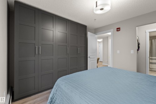 Expansive built-in wardrobe featuring contemporary panel doors and brushed nickel hardware - 210 2229 44 Avenue, Edmonton, AB 