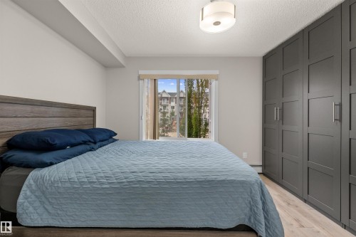 Built-in wardrobe system featuring dark paneled doors and silver-tone hardware - 210 2229 44 Avenue, Edmonton, AB 