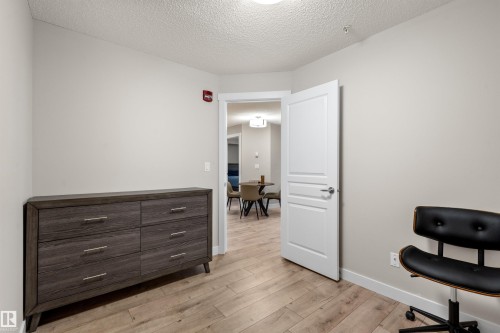 Light-toned walls complement the wood-finish flooring - 210 2229 44 Avenue, Edmonton, AB 