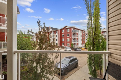 Balcony featuring glass panel railing and vinyl siding - 210 2229 44 Avenue, Edmonton, AB 