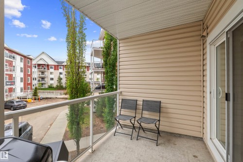 Private balcony featuring concrete flooring, glass railing, and beige horizontal siding - 210 2229 44 Avenue, Edmonton, AB 