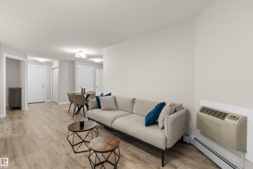 Open-concept living area featuring wood-finish flooring, recessed lighting, and light-toned walls - 210 2229 44 Avenue, Edmonton, AB 