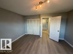 Bedroom featuring contemporary gray walls and wood-finish flooring - 