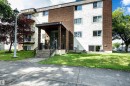 Multi-story building exterior featuring a brick and textured stucco facade - 202 10740 105 Street, Edmonton, AB 