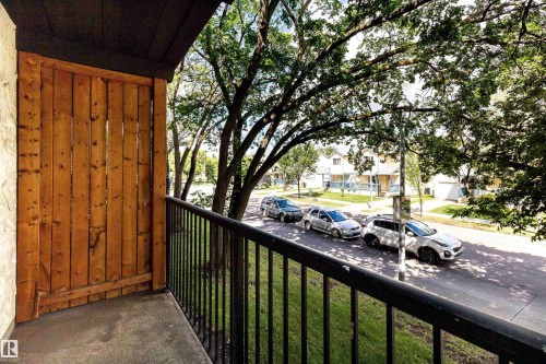 Private balcony featuring a wood privacy screen, black metal railing, and concrete flooring - 202 10740 105 Street, Edmonton, AB 