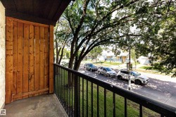 Private balcony featuring a wood privacy screen, black metal railing, and concrete flooring - 