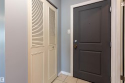 Entryway featuring a paneled door with brass hardware, tile flooring, and a louvered bi-fold closet door - 