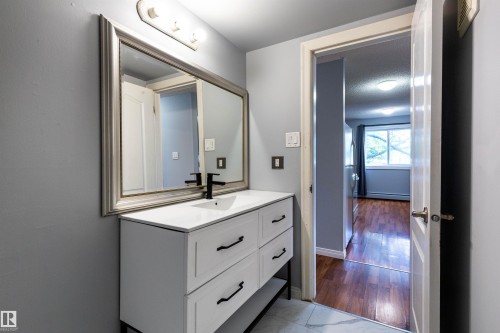Bathroom vanity featuring a white countertop, under-mount sink, and matte black faucet - 202 10740 105 Street, Edmonton, AB 