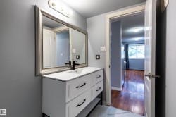 Bathroom vanity featuring a white countertop, under-mount sink, and matte black faucet - 