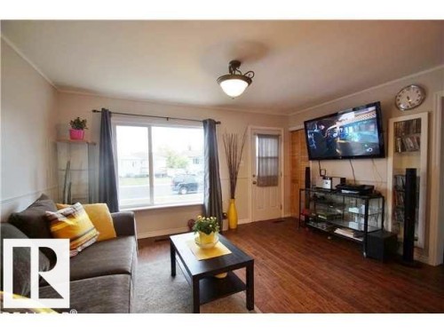 Living area featuring wood-finish flooring and a large picture window - 9815 160 Street, Edmonton, AB 