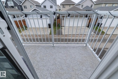 Balcony featuring a textured light grey surface, white metal railing, and white string lighting - 46 4050 Savaryn Drive, Edmonton, AB 
