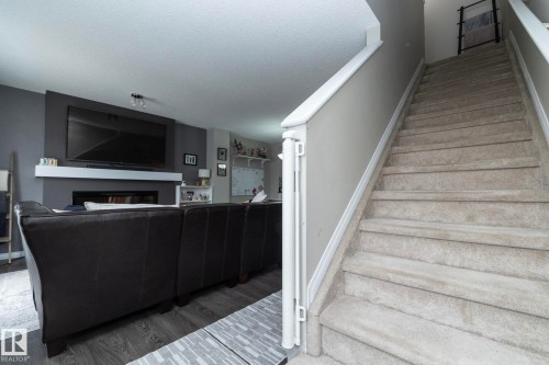 Carpeted staircase with white trim leading to upper level - 46 4050 Savaryn Drive, Edmonton, AB 