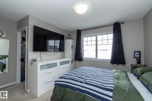 Bedroom featuring a window with grid pattern, light gray walls, and carpet flooring - 46 4050 Savaryn Drive, Edmonton, AB 