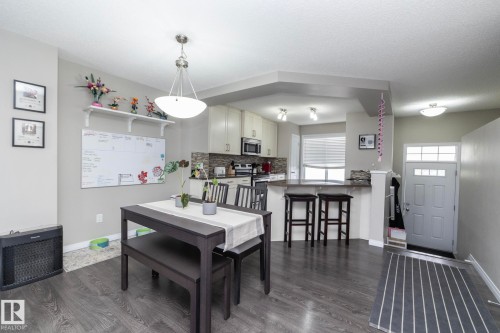 Spacious main living area featuring wood-finish flooring, a contemporary dining area, and recessed lighting - 46 4050 Savaryn Drive, Edmonton, AB 