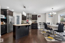 Open-concept kitchen and dining area featuring rich wood-finish flooring - 