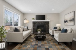 Living room featuring a dark stacked stone fireplace with white mantel, a large window with horizontal blinds, recessed lighting, and dark wood-finish flooring - 