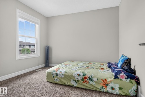 Carpeted room featuring a double-hung window with white trim, light gray walls, and white baseboards - 3350 18B Street, Edmonton, AB 