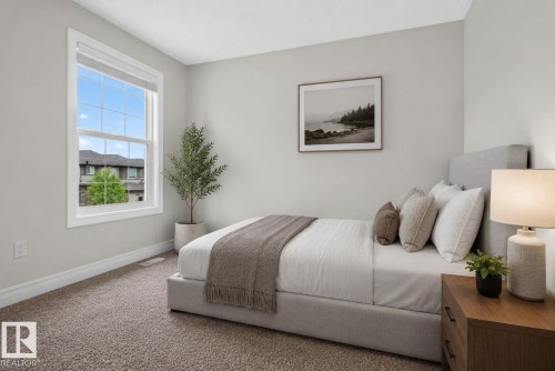 Spacious bedroom featuring light neutral wall paint, white trim, and plush carpet flooring - 3350 18B Street, Edmonton, AB 